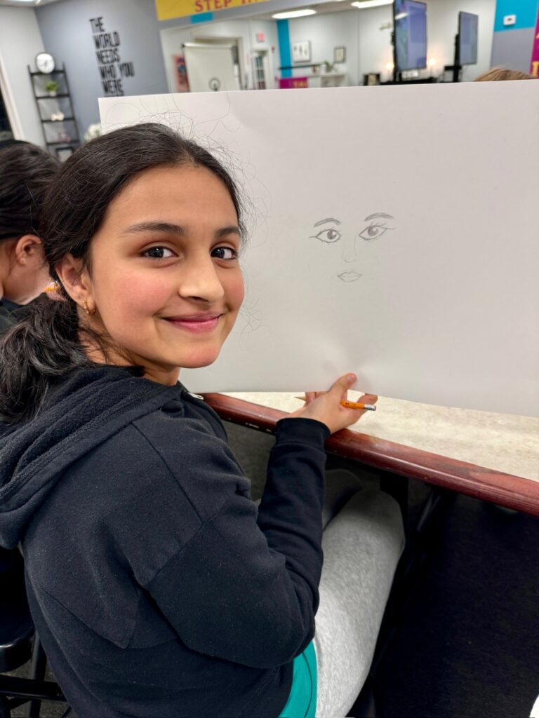 Smiling teenage girl displays an art project
