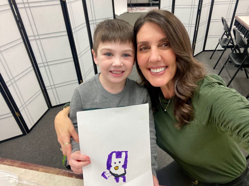 Maria empowering a young boy at Fearless Focus in Pembroke to express his creativity 